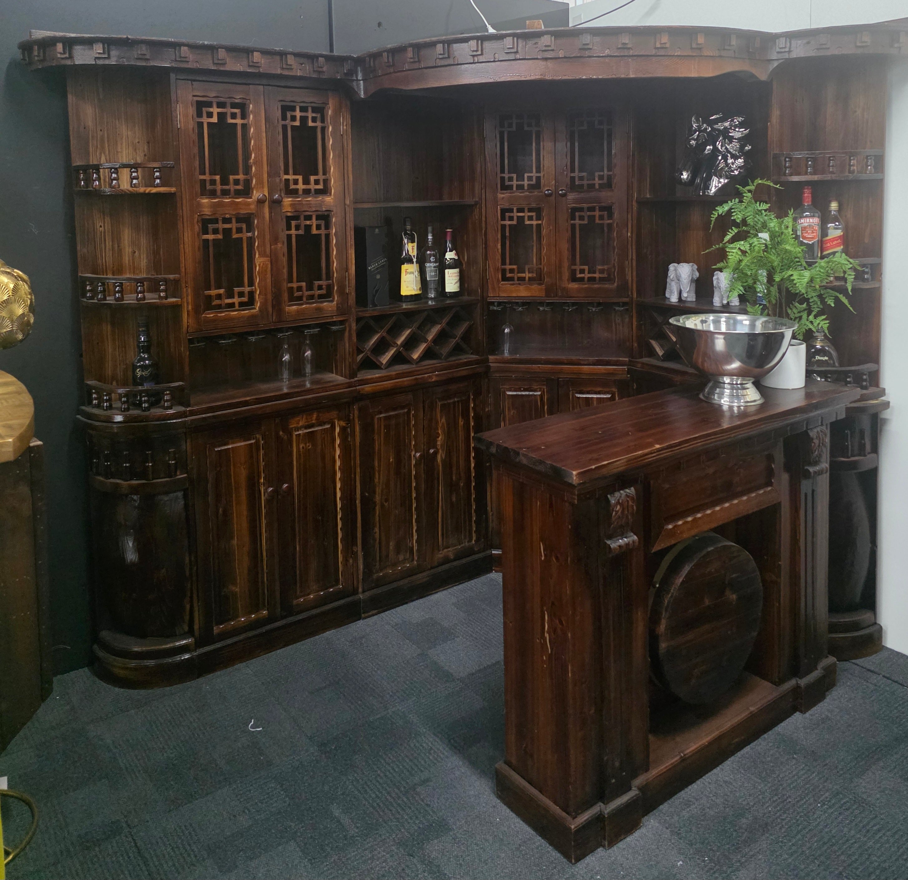 Wooden bar cabinet with shelves and a countertop in a room setting.