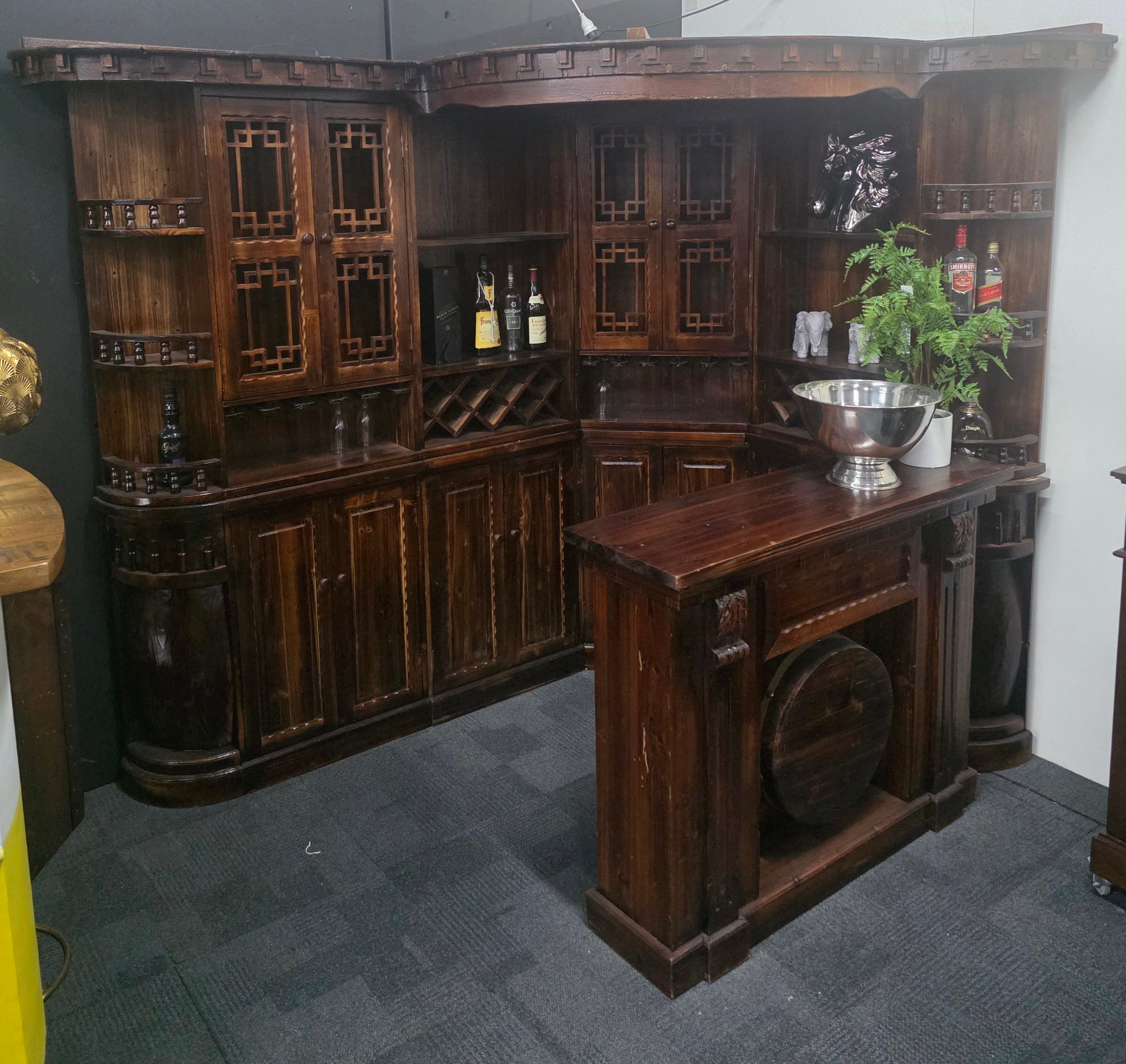 Wooden bar cabinet with shelves and a countertop in a room setting.