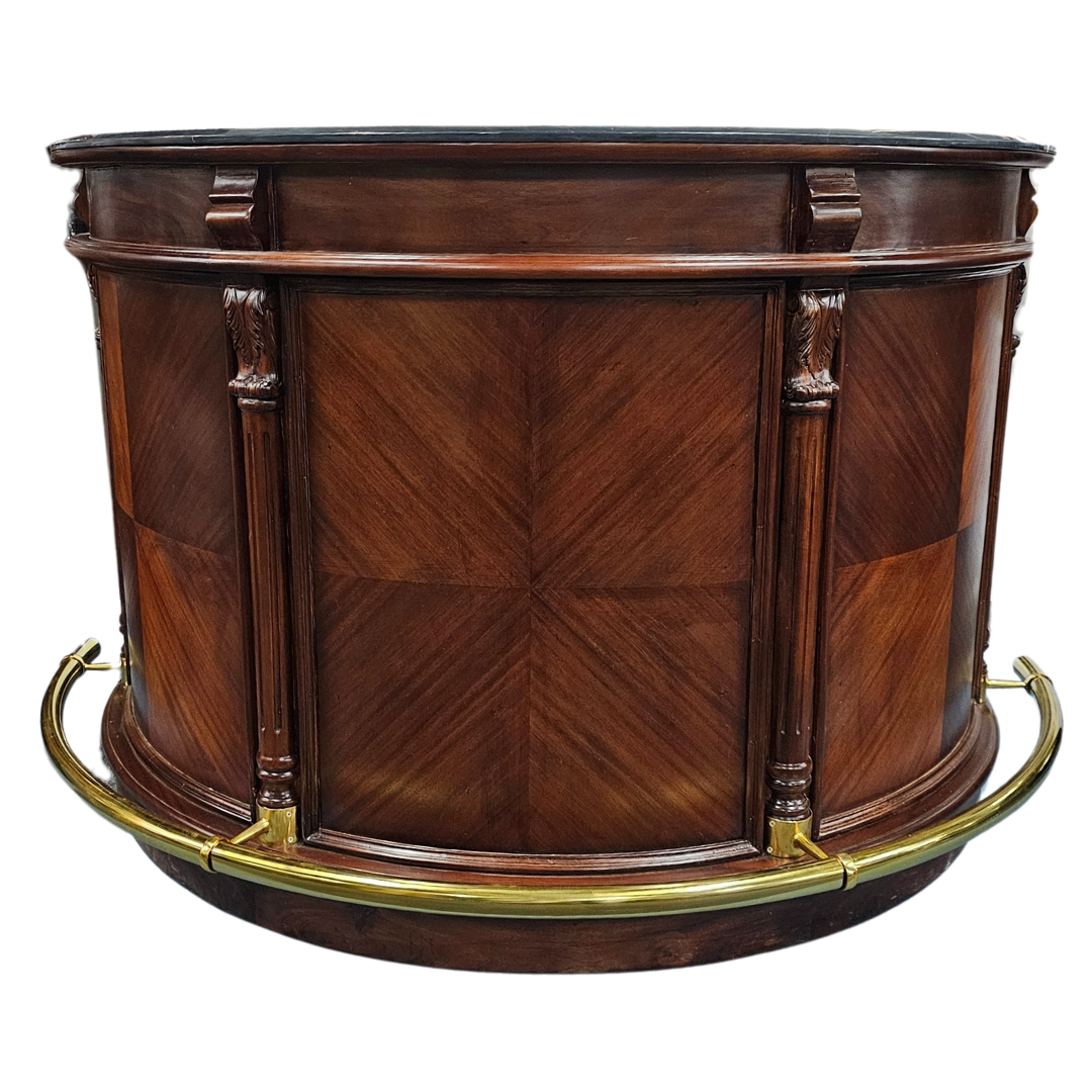 Elegant Niagara Bar Counter made from mahogany with a rare granite top, carved columns, glass side doors, and a brass-tone footrest.