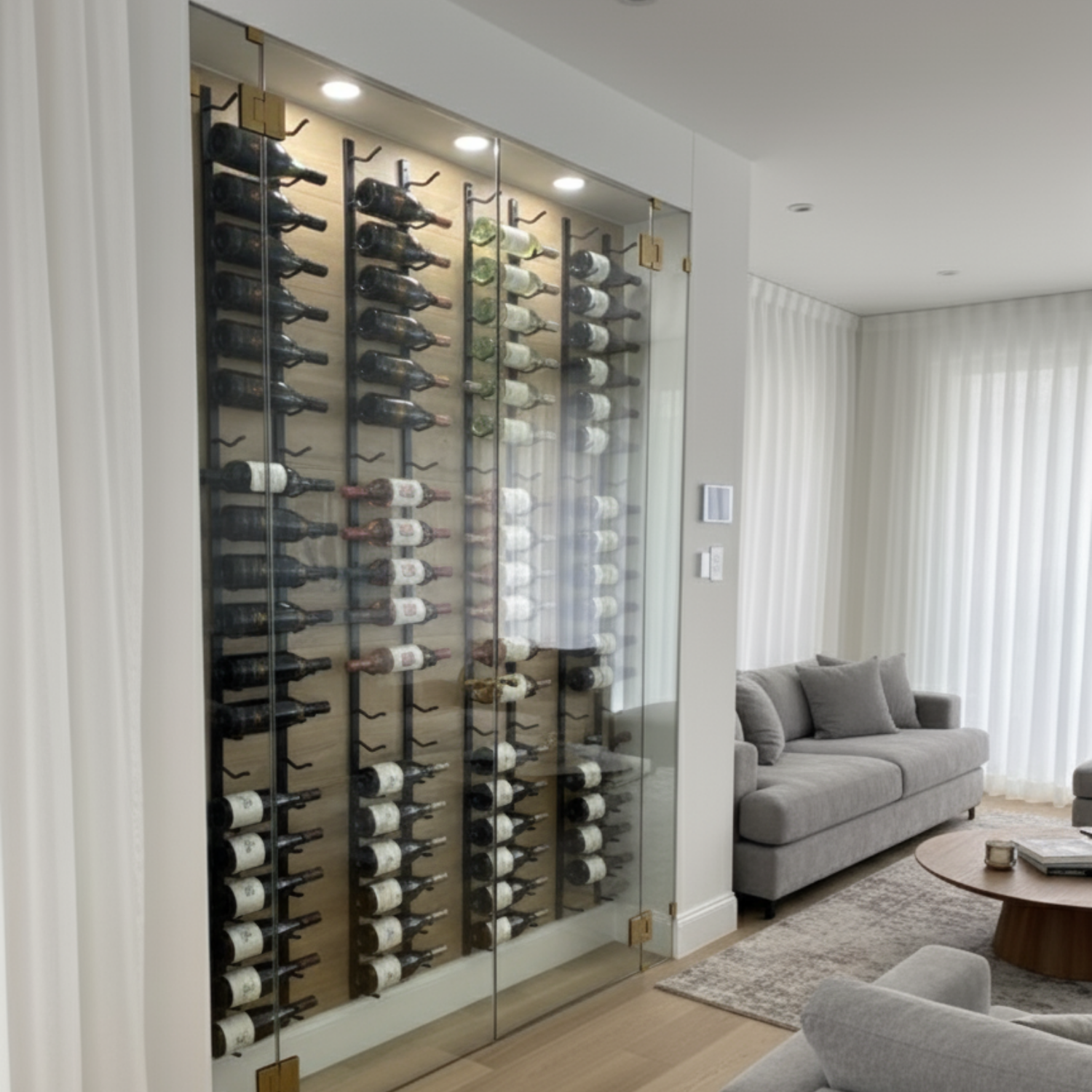 Wine bottles arranged vertically on a wall-mounted glass rack in a modern living room.